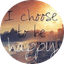 Beach scene with mountains and city skyline at sunset, text reads "I choose to be happy